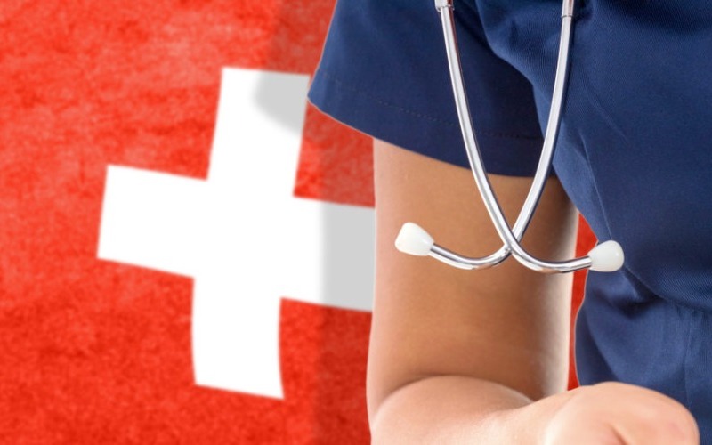 switzerland-flag-female-doctor-with-stethoscope-national-healthcare-system-1140x533-fddfd7.jpg