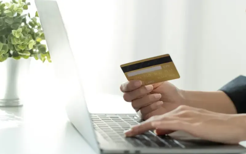 woman-using-laptop-holding-credit-card-indoors-2026-03-17-00-50-45-utc-scaled-c335cb.webp